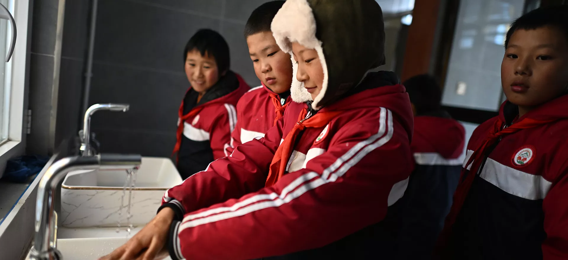 在青海省果洛藏族自治州玛多县花石峡镇藏文中心寄宿制学校，五年级学生东桑（右一）在使用厕所后洗手，该学校是环境卫生特别项目学校之一（11月2日摄）。