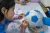 A girl draws on a football to express her opinion about child rights at the UNICEF compound in Beijing, China, on 5 November 2022.