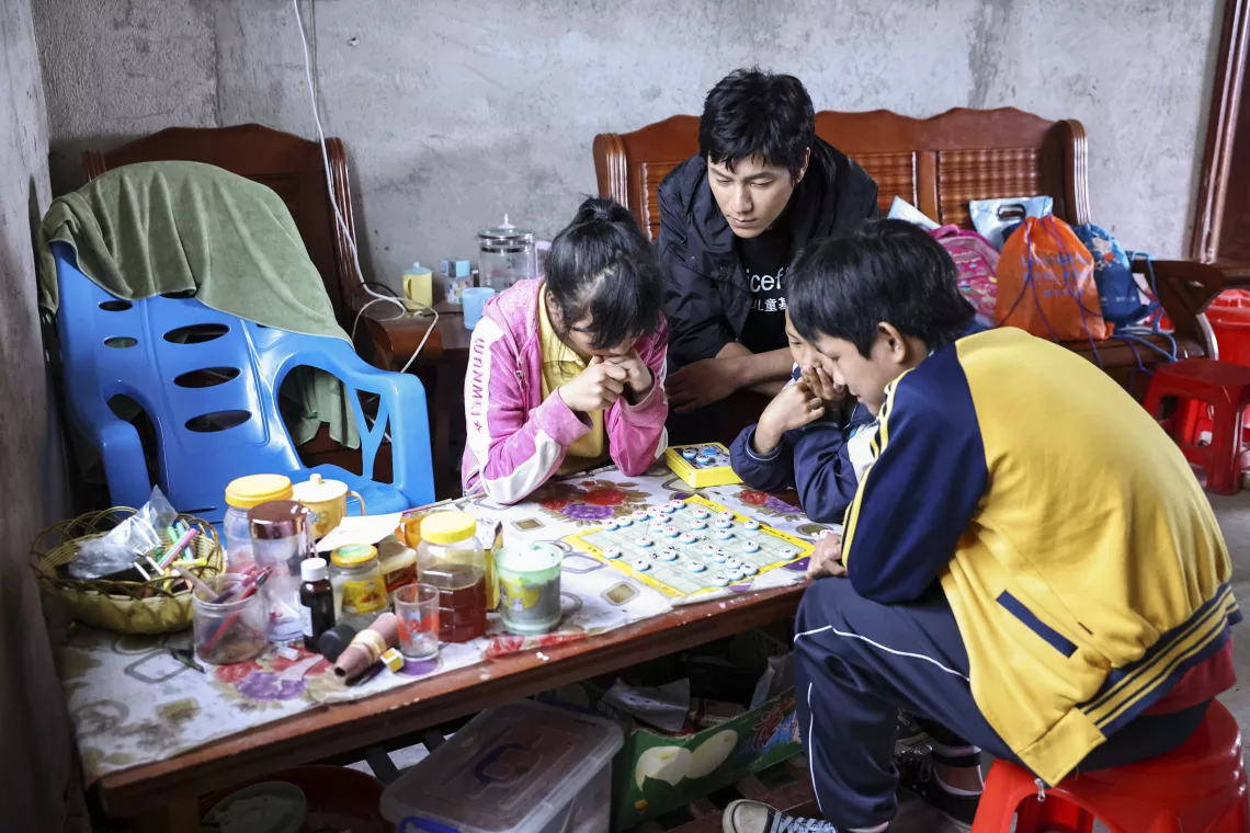 UNICEF Ambassador and renowned actor Chen Kun watches children playing chess during a visit to Lingshan County, Guangxi Zhuang Autonomous Region, on 13 May 2023. Chen Kun visited Lingshan County from 12-14 May 2023 to meet children and caregivers taking part in the Integrated Child Protection Model programme jointly supported by UNICEF and the Ministry of Civil Affairs.