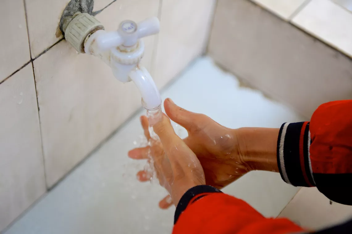 2015年，一名男孩在重庆忠县的一所小学内洗手。