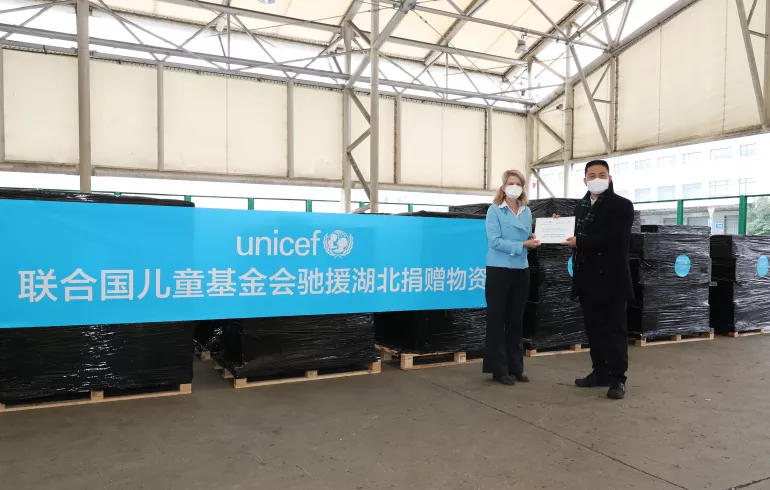 Cynthia McCaffrey, UNICEF Representative to China, presents a handover certificate to Xu Xingfeng, Deputy Commissioner of the Commissioner’s Office in Shanghai under the Ministry of Commerce, at the cargo area of Pudong International Airport in Shanghai on 1 March 2020.