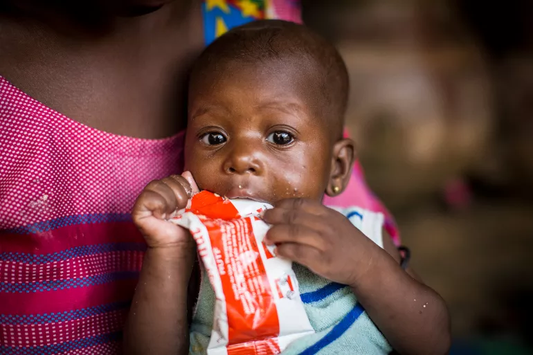 在马里，一名6个月大的男婴在家中食用即食治疗性食品。