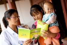 云南武定县的村医指导母亲给孩子服用营养包。