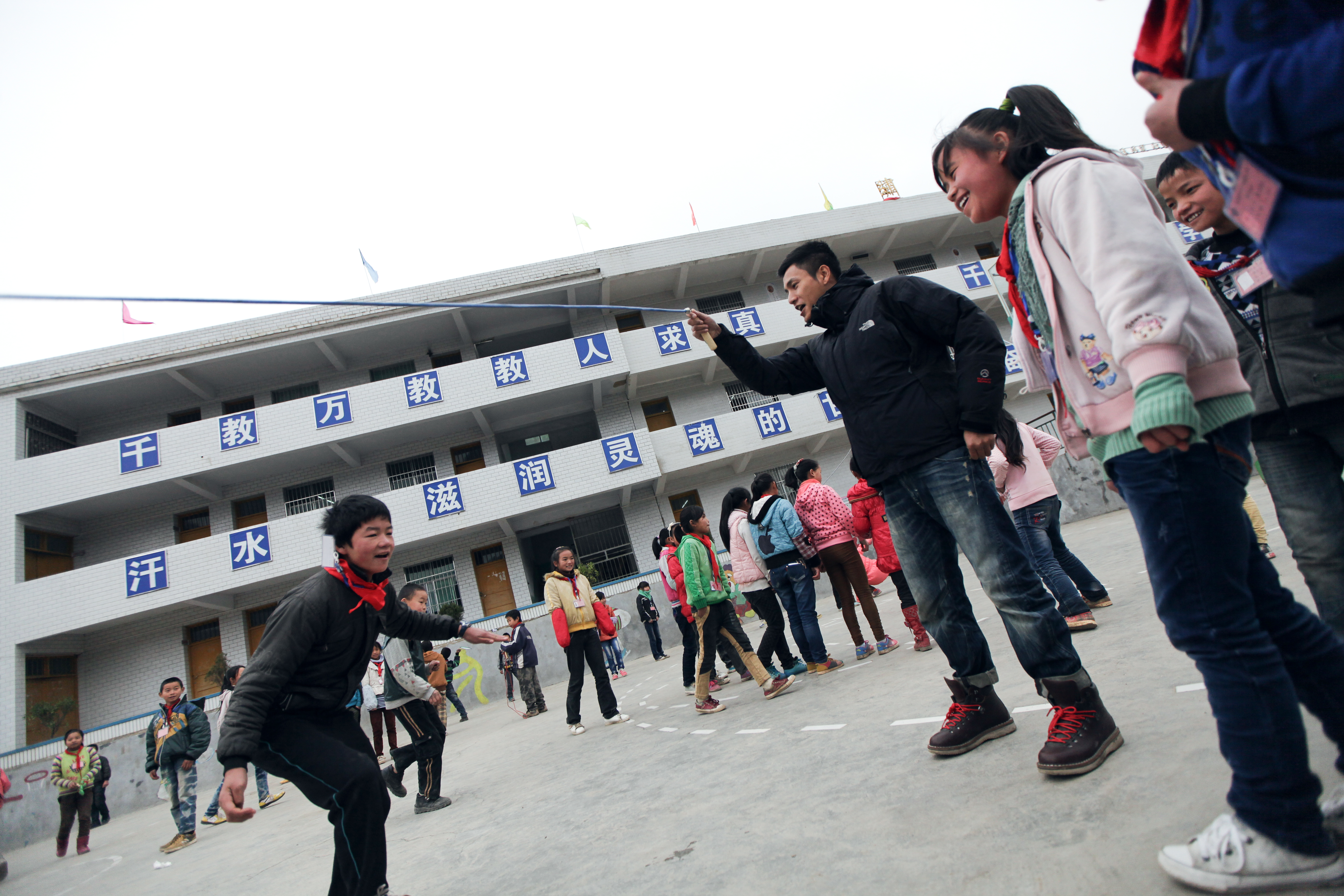 陈坤在纳雍县的一所小学与孩子们一起跳绳。