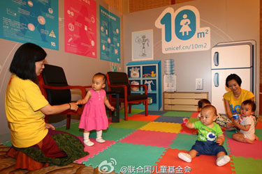 妈妈宝宝们在母爱10平方活动启动仪式现场临时搭建的母乳喂养室里玩耍。