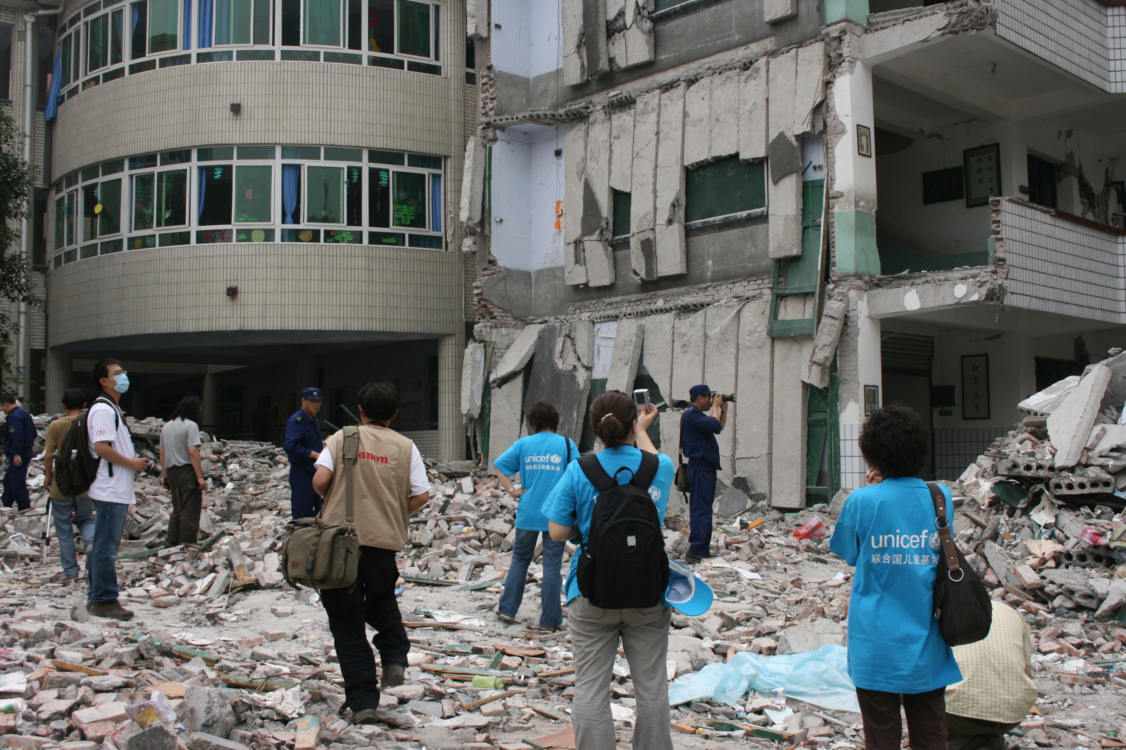 UNICEF staff members( in blue T-shirts) visit the Xinjian Primary School in Dujiangyan that collapse in the earthquake on May 24.