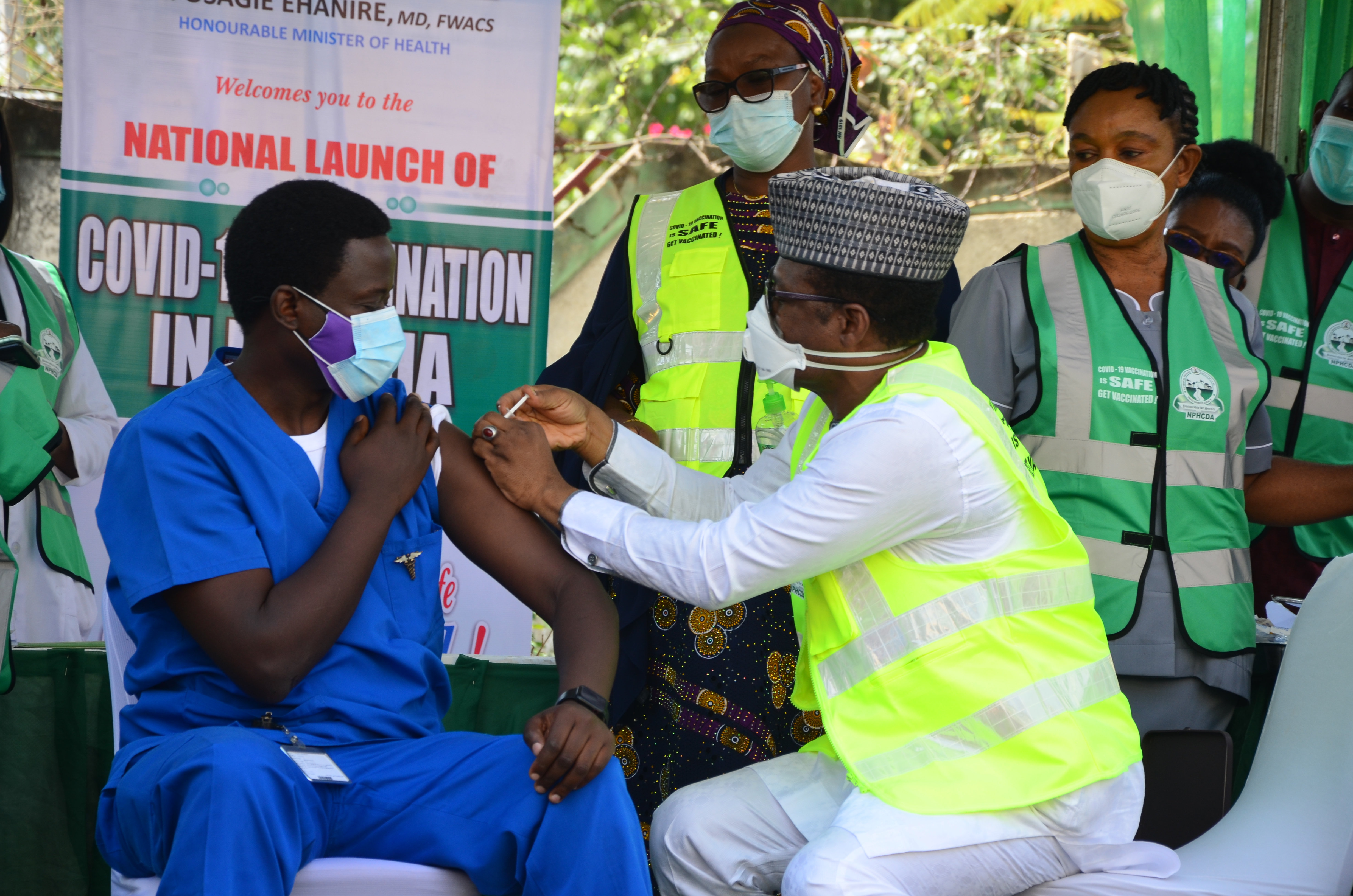 2021年3月5日，尼日利亚阿布贾，Cyprian Ngong博士（左一）是首位接受NPHCDA执行主任Faisal Shuaib博士注射疫苗的男性卫生工作者。