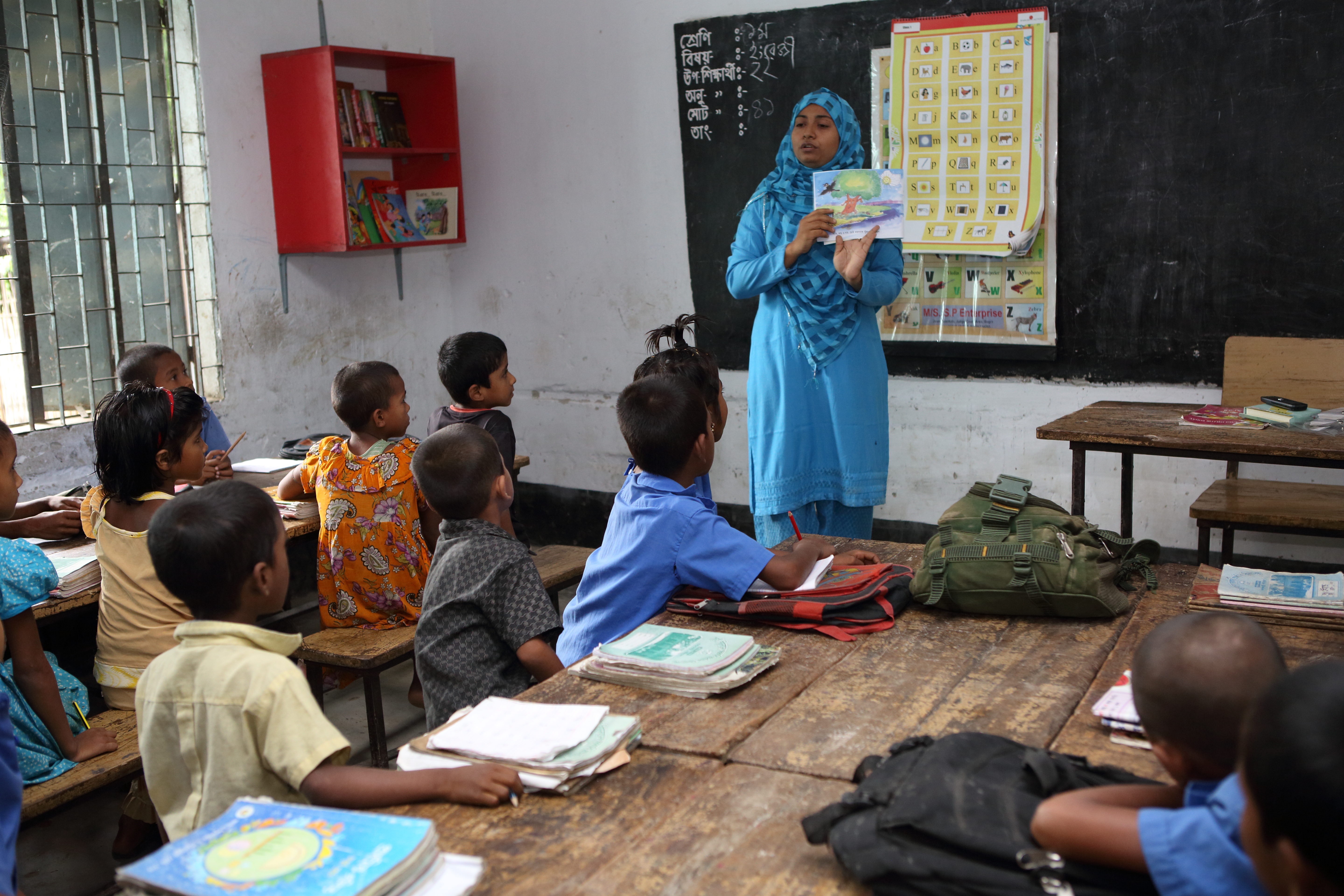泰妮雅·罗姗是孟加拉国盖班哈一所小校的校长，2014年6月23日，她正在用课外阅读材料为孩子们上课。