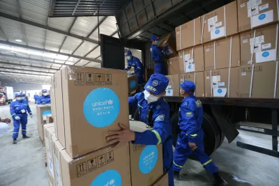 Volunteers carry down UNICEF donated supplies in an emergency warehouse of the Hubei Charity Foundation in Wuhan, the epicenter of the COVID-19 outbreak, on 18 March 2020.