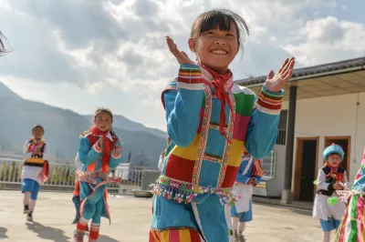 在云南省腾冲烧灰坝小学，一个女生和同学们一起跳舞。