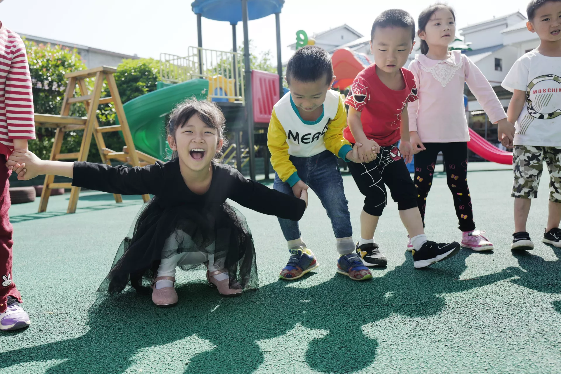 Children in the Yelang Village Kindergarten play games at the playground.