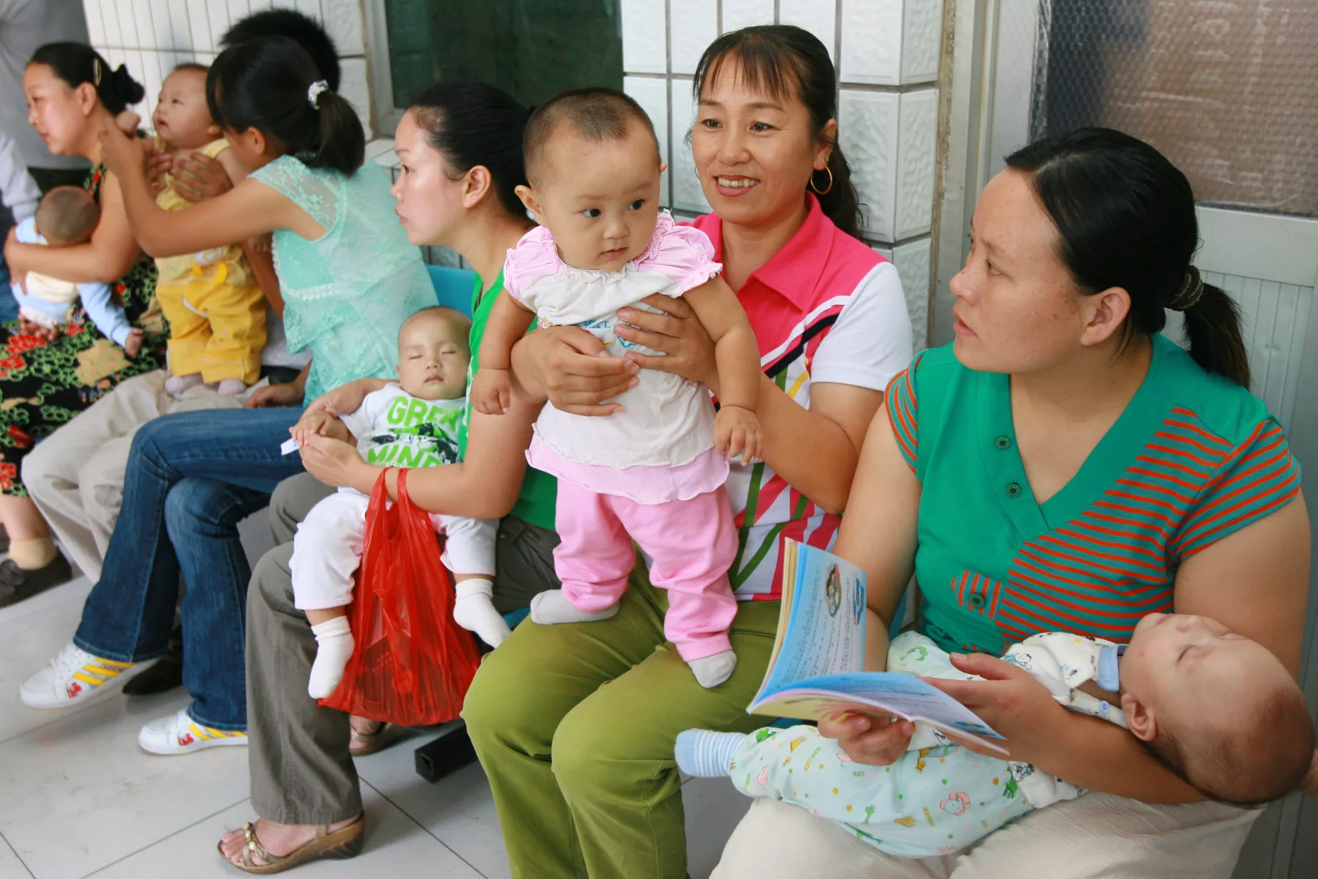 Mothers wait to have their children get health check at the Community Health Centre in Shibalidian of Beijing, one of the project sites supported by UNICEF and WHO, in 2007.