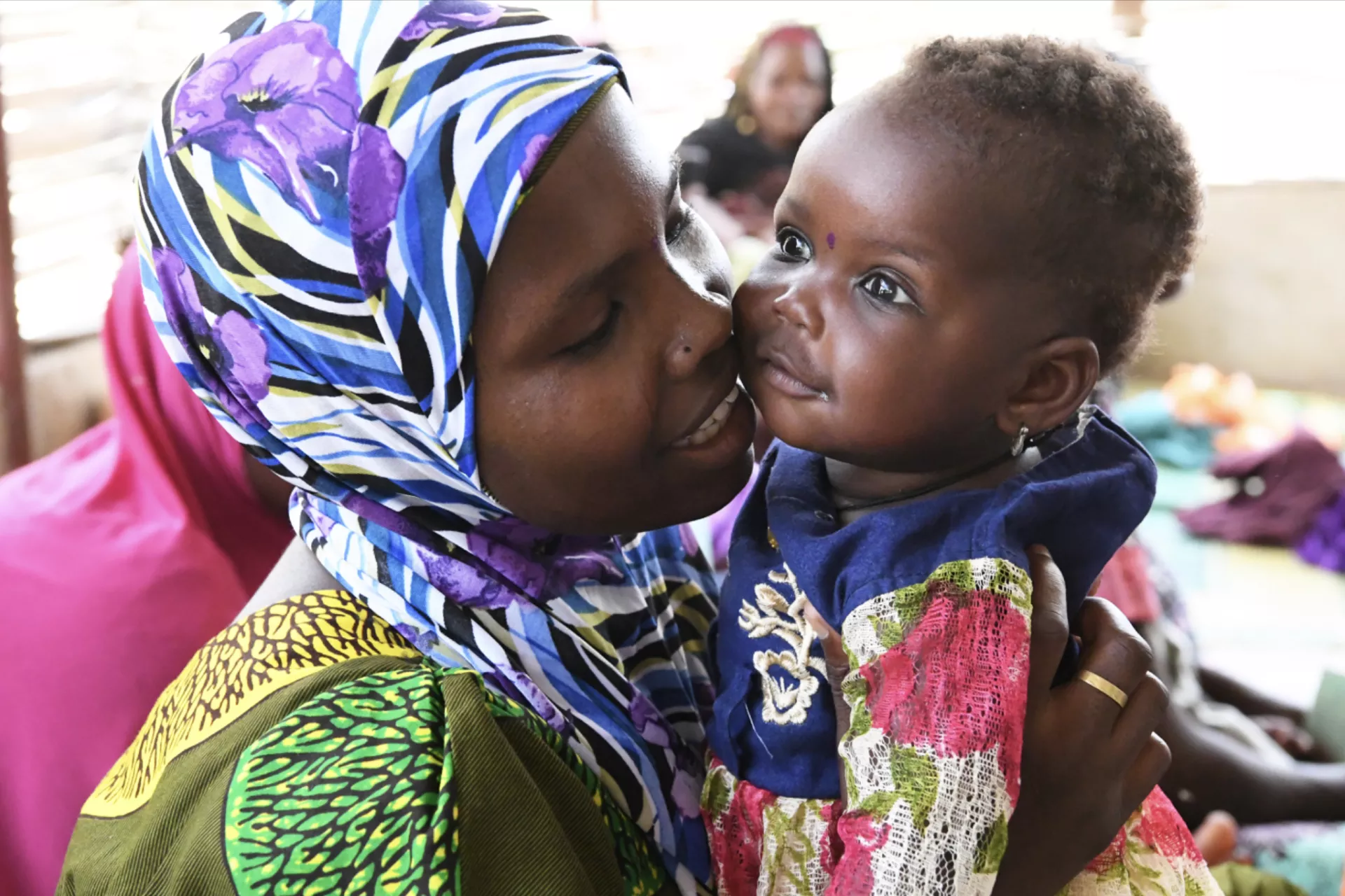A woman is cuddling her baby after being vaccinated at the health center in a village in the center of Niger.