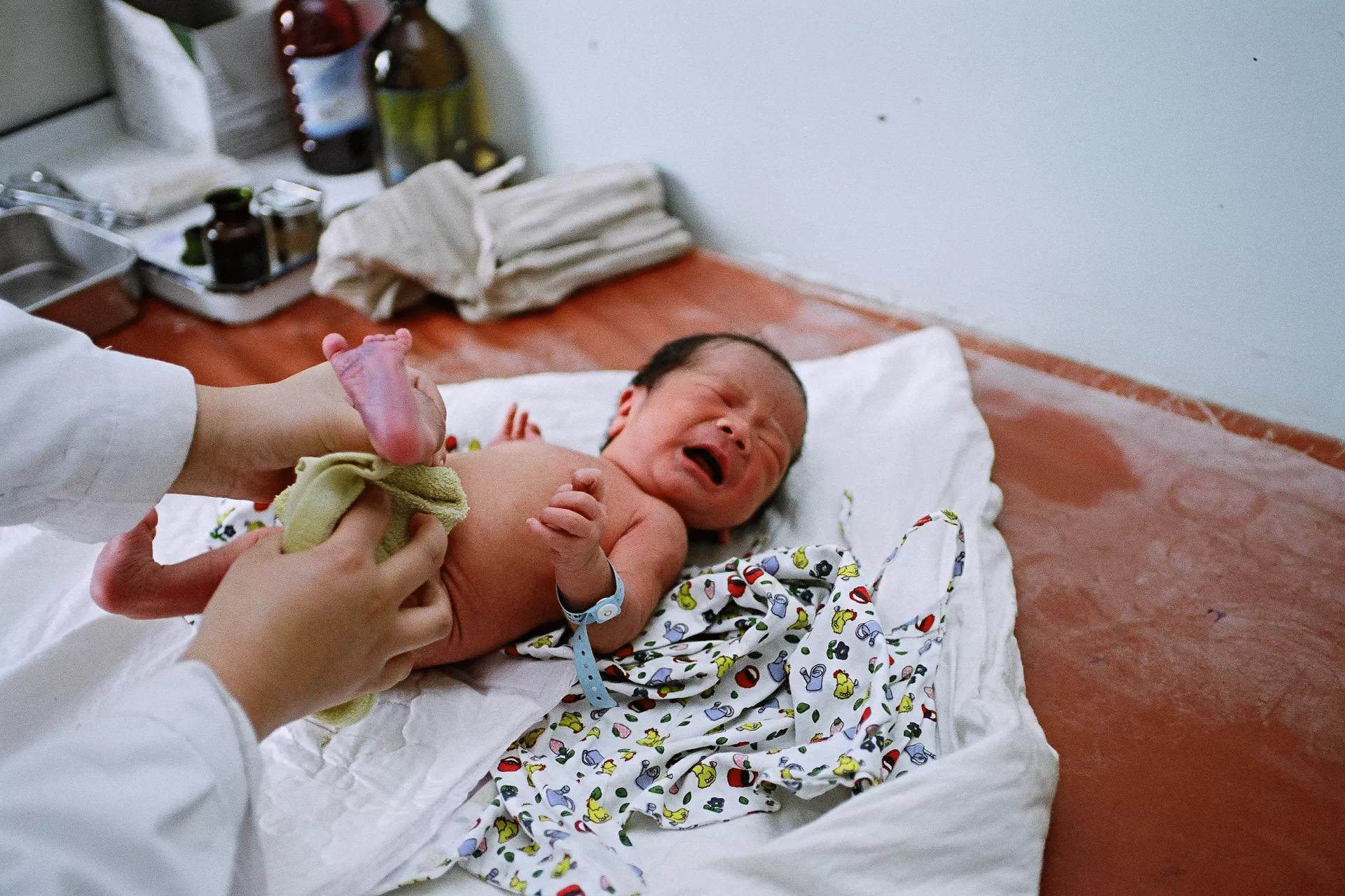 2008年，在甘肃的一所卫生院里，医务人员为一名新生儿检查身体。 
