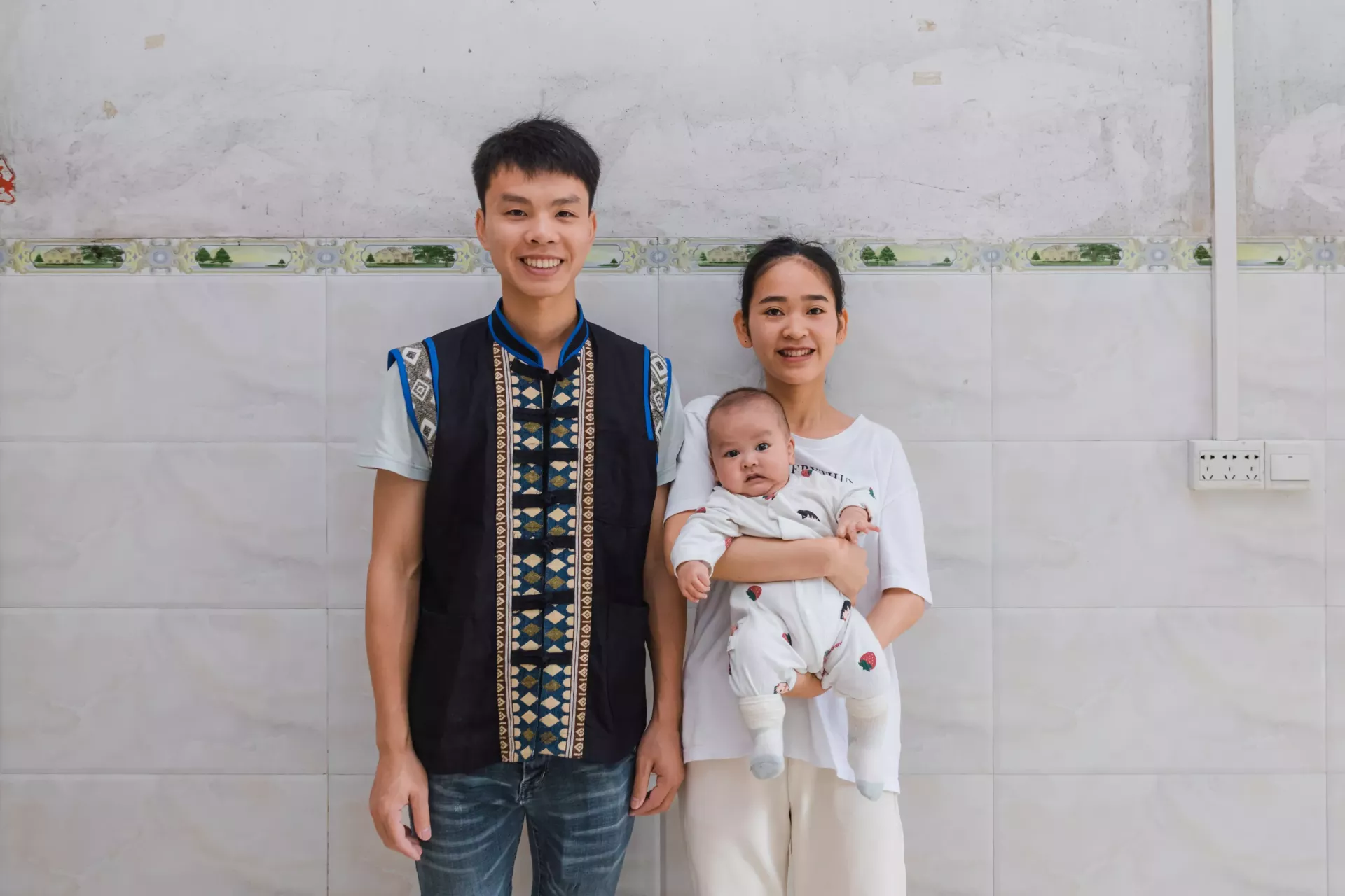 Parents and their 6-month-old child pose for photo in Pingguo, Guangxi province, China, on 18 April 2023.
