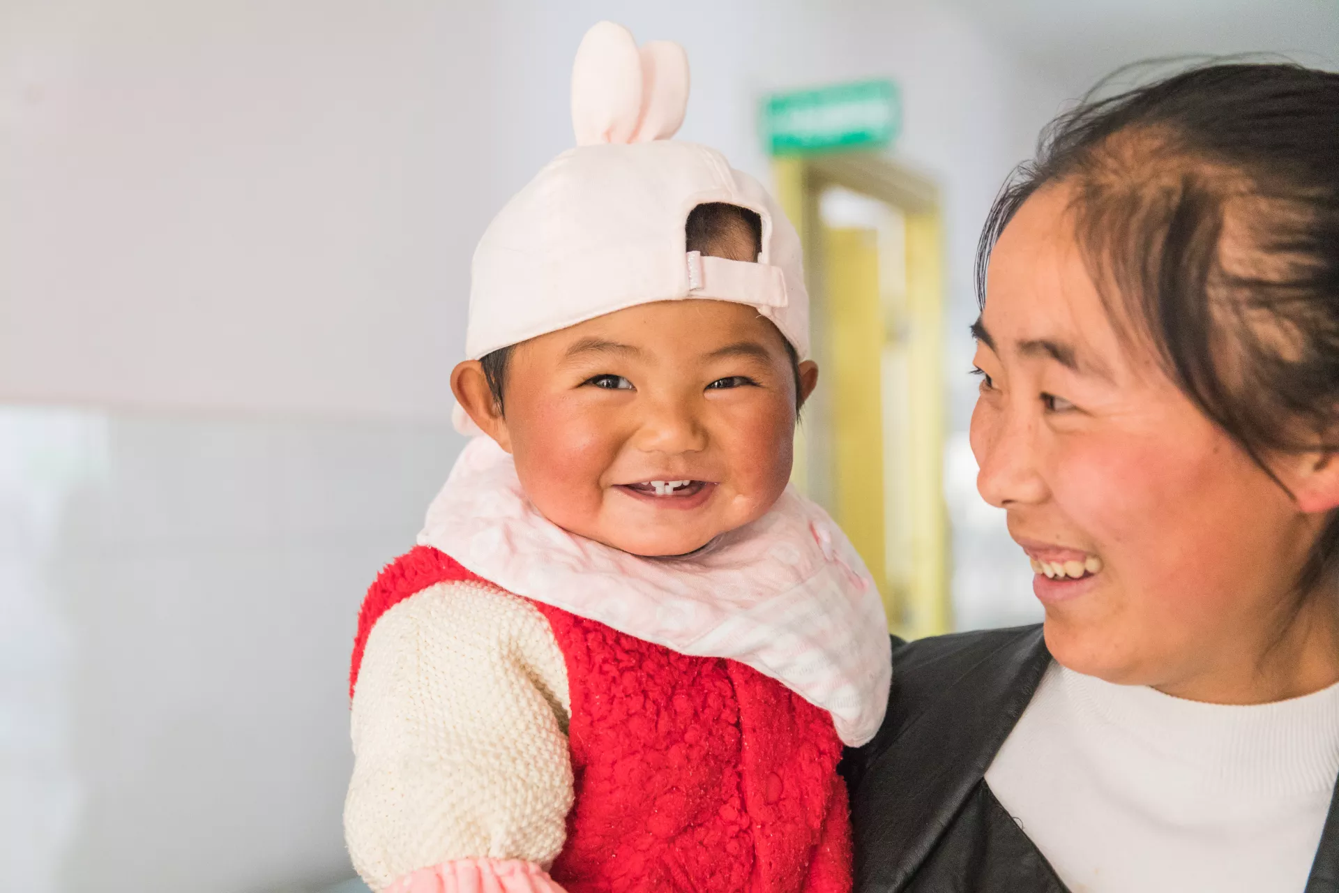 A mother holds a baby after paying a visit to the maternal and child hospital in Yulong County, Yunnan Province, in 2018. 