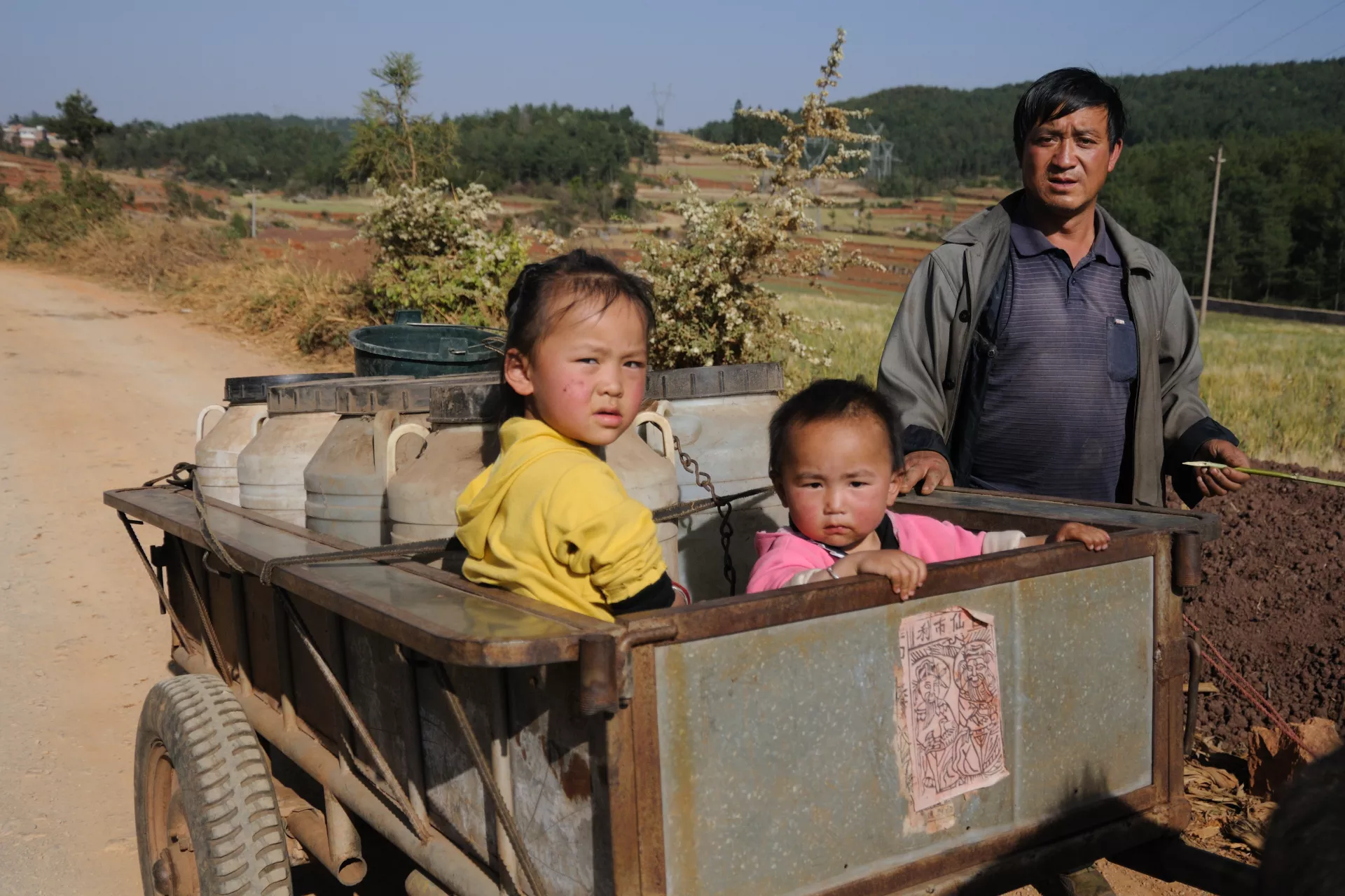 Zhu Kaifa and his two granddaughters on their way back home after they've fetched water.