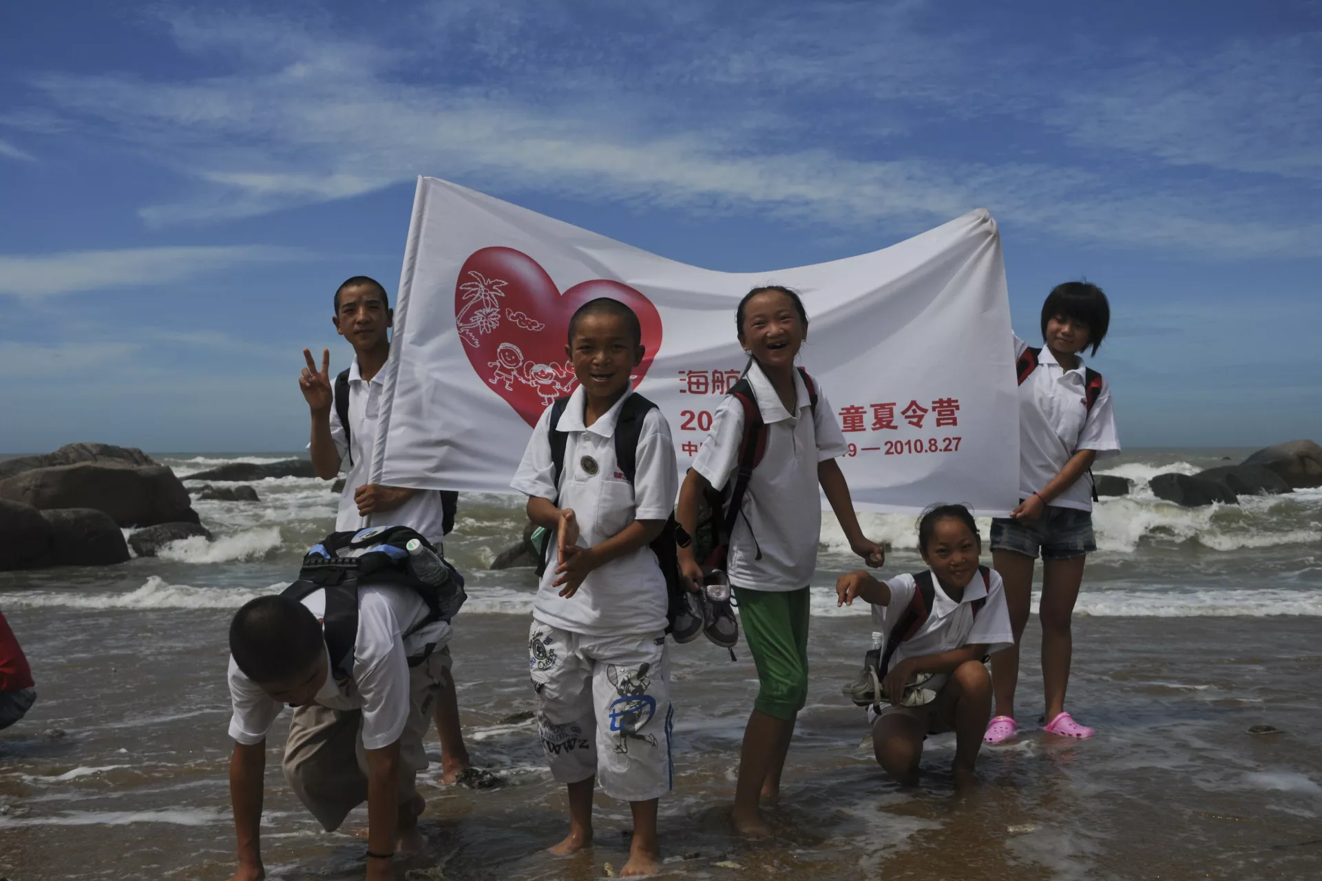Children pose for a photo by the sea side.