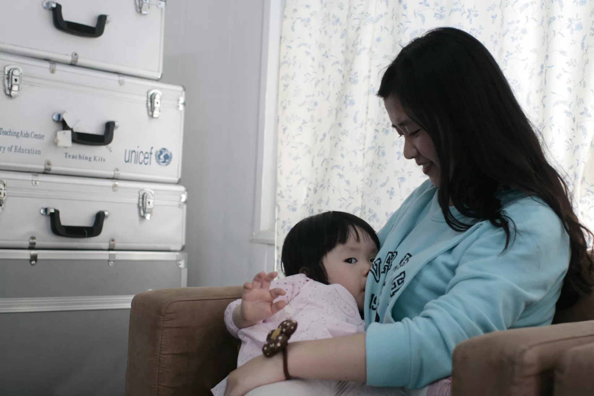 2013年，在北京的联合国儿童基金会驻华办事处母乳喂养室里，一名妈妈给孩子喂母乳。 