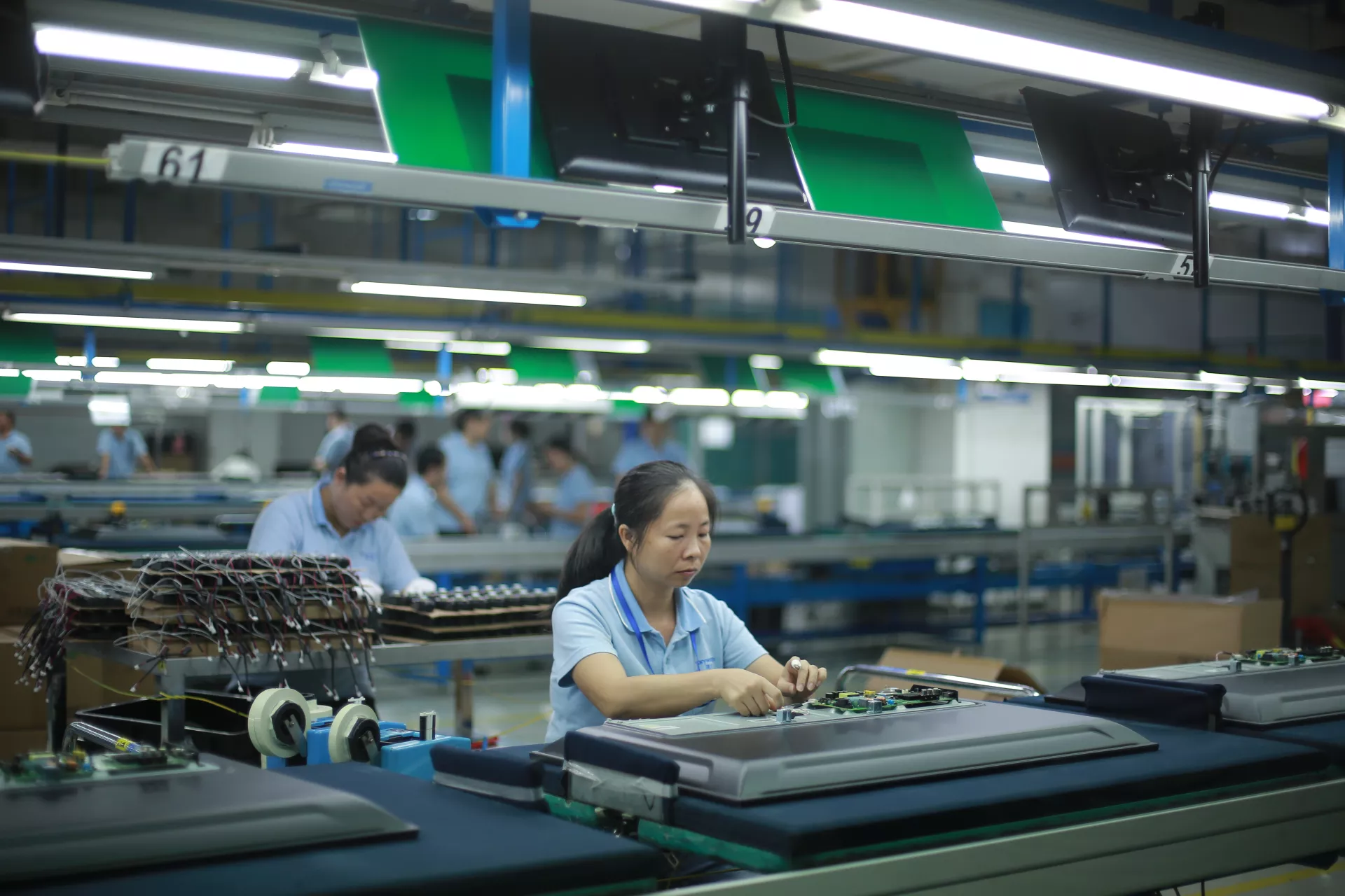 2019年7月11日，在广东省深圳市的一家工厂内，一名工人正在组装电视机芯片。