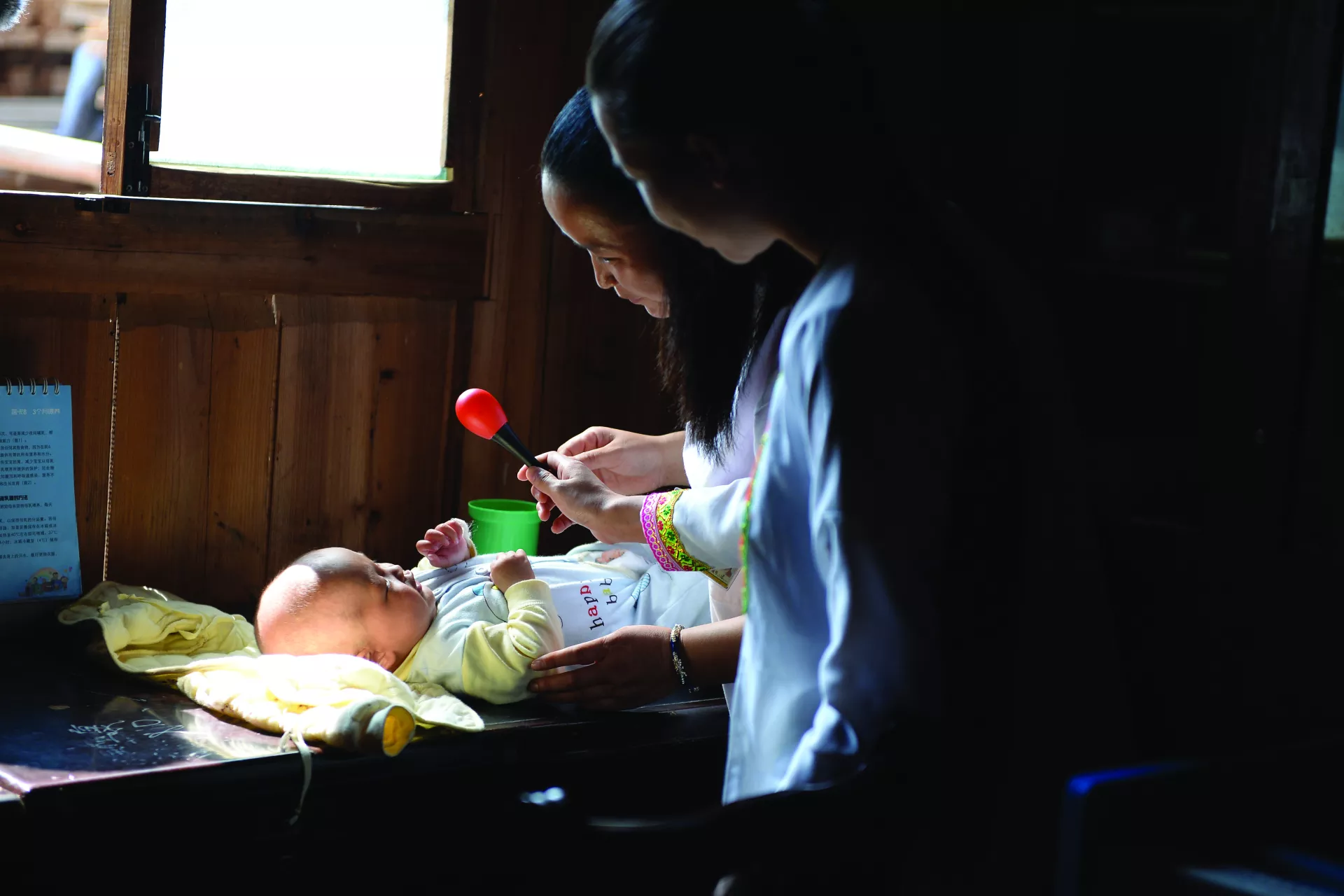 贵州省黎平县的一家诊所内，一名卫生工作者正在检查一个孩子的发育状况。
