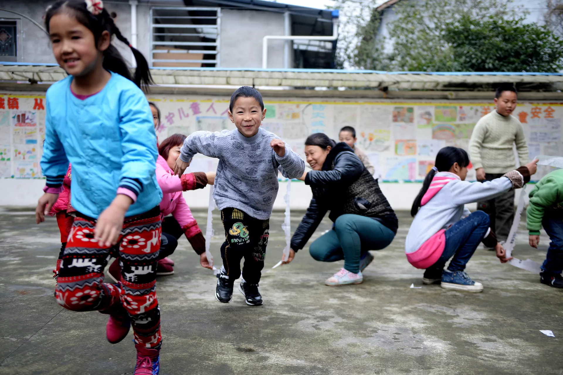 Boys and girls playing in school, China.