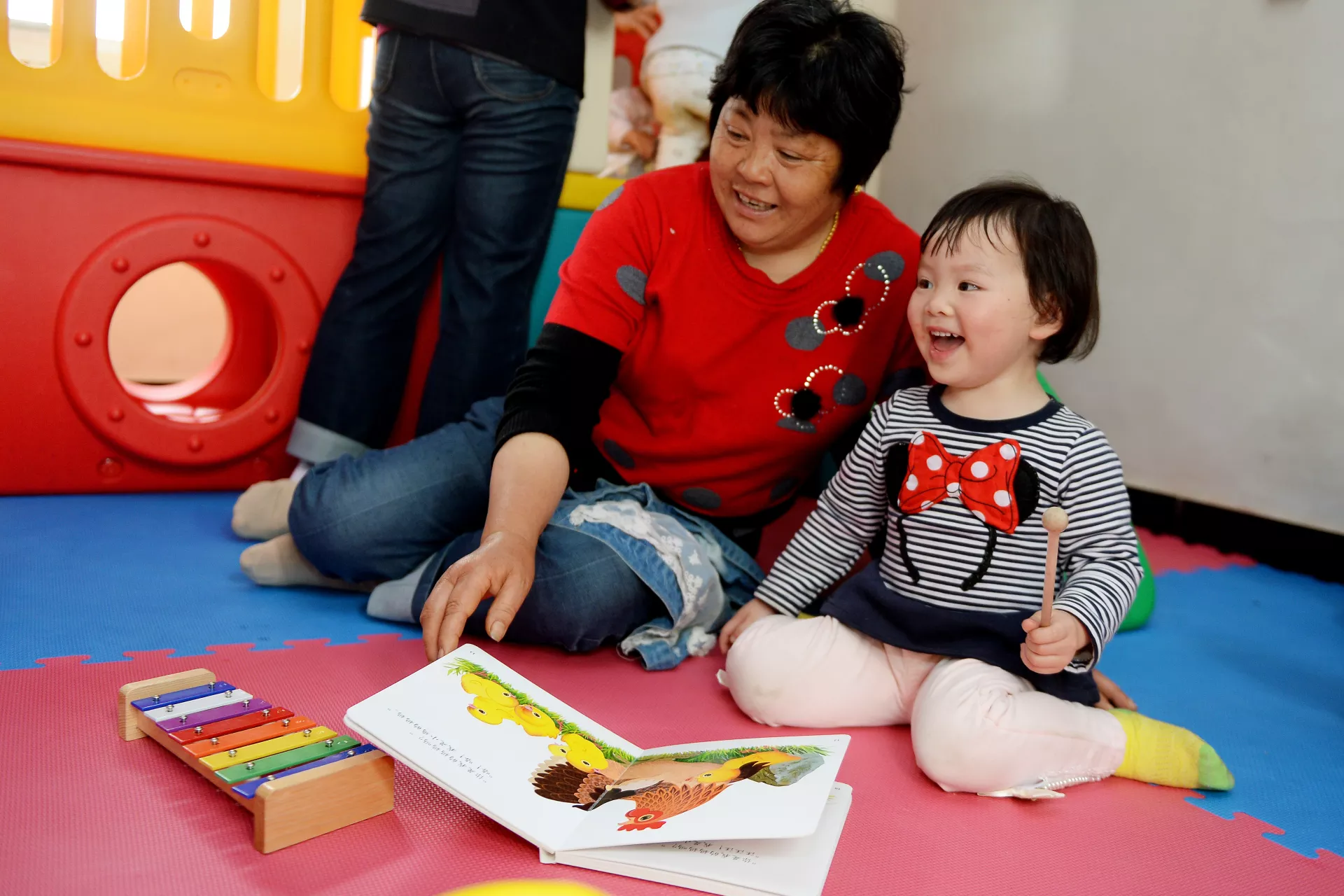 A girl and her caregiver join activities at the ECD centre in Ai village, on the outskirts of Yichang City in Hubei Province.