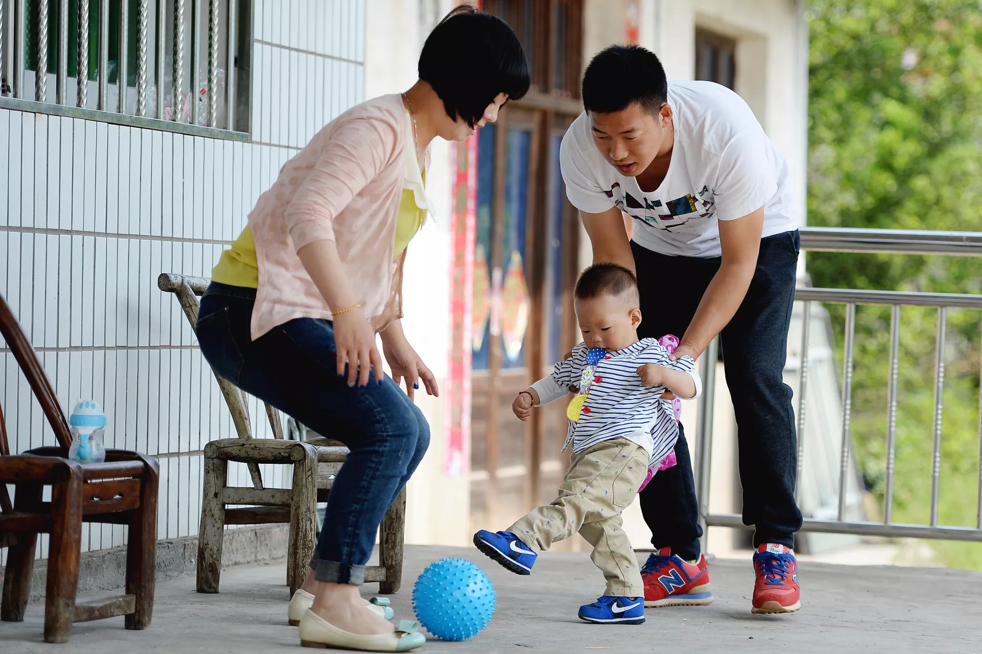 2015年四月，在湖北省宜昌市灵宝村，一对年轻父母与他们的孩子一起玩耍。
