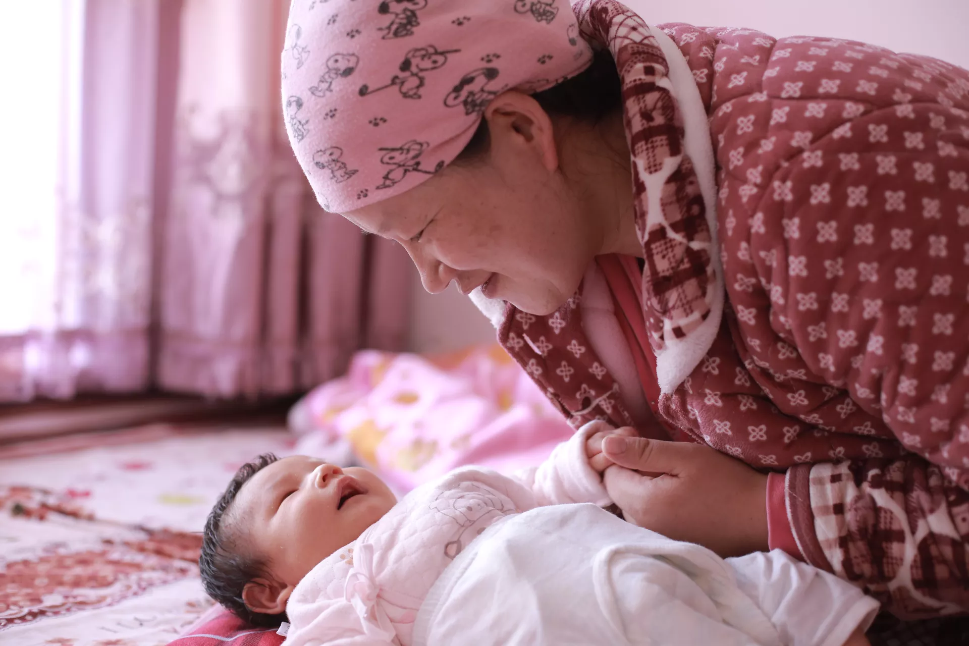 在宁夏吴忠市红寺堡区，一名母亲在家中照料刚出生的孩子。