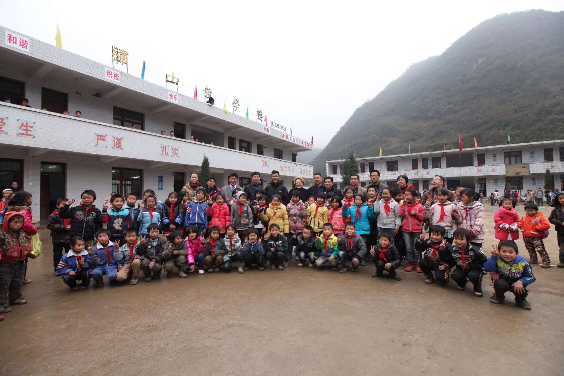 Chen Kun is having a group photo with students and teachers in Xinzhai primary school in Zhuchang Village.
