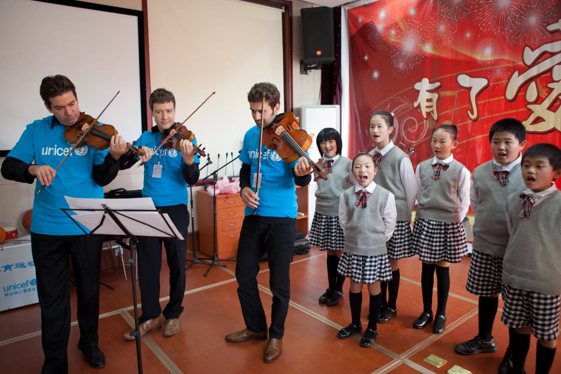 Violist Micha Afkham (center) and violinist Krzysztof Polonek (right) of the Berlin Philharmonic prepare to perform at the Shangzhuang Zhongxin Primary School on 9 November 2011.