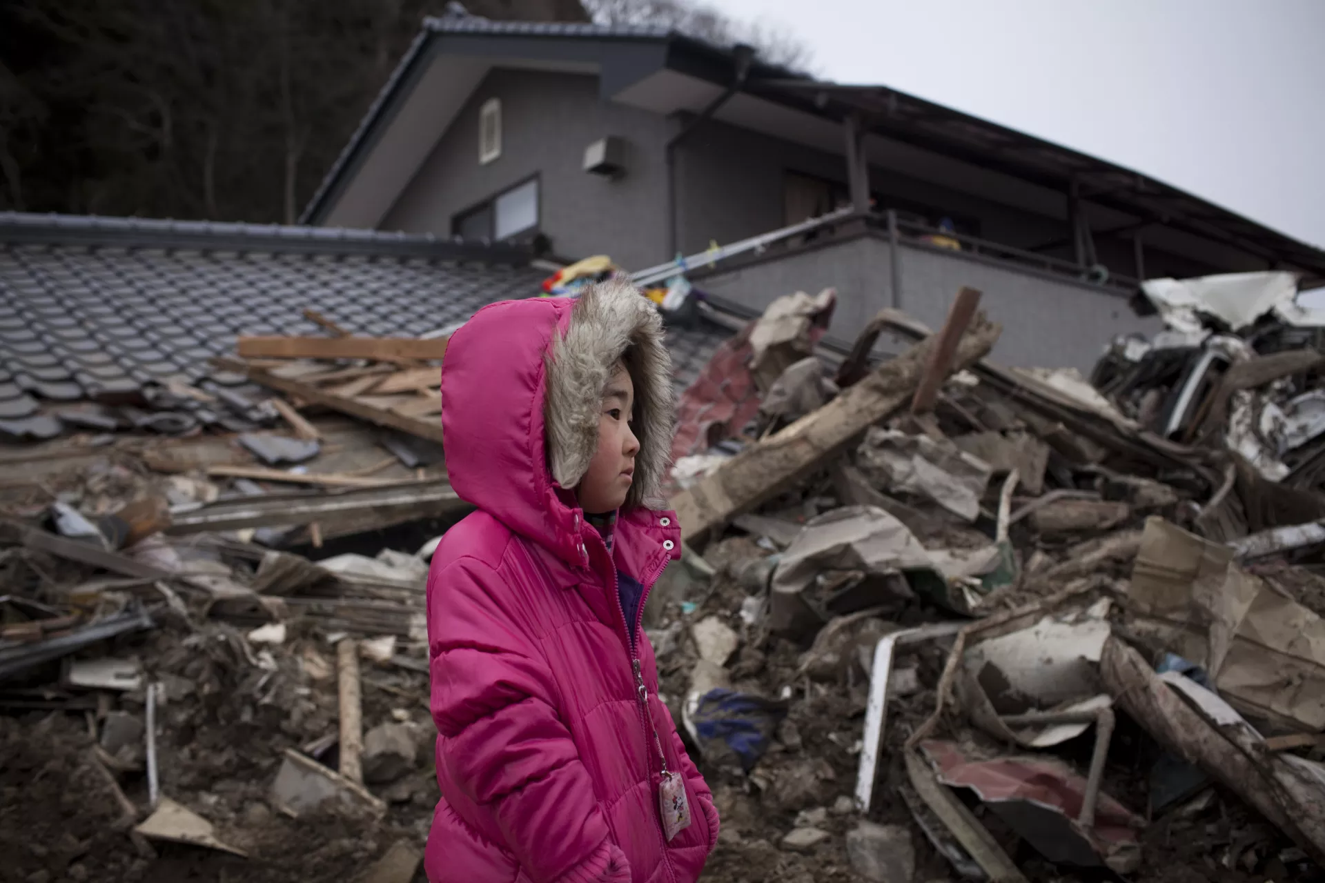 5岁的尼娜(Neena) 站在废墟前。