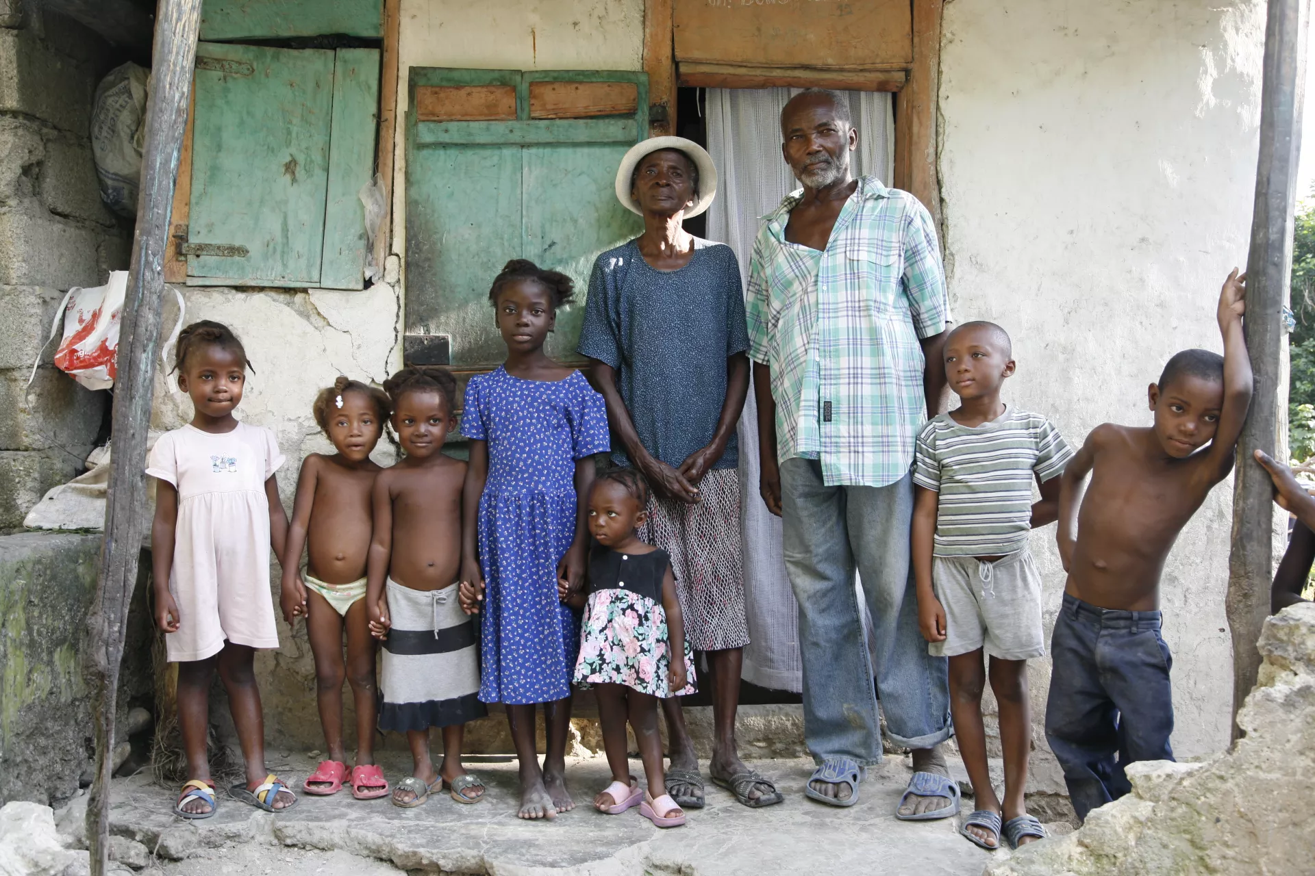 在海地，Kebo Bouquet夫妇和孙子孙女们站在家门外。