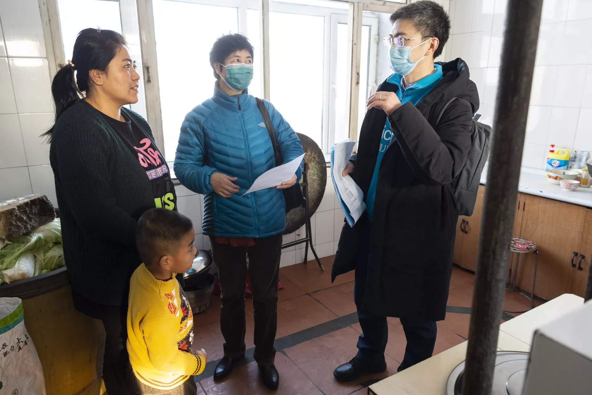 Sun Hui (1st from right), a programme officer from UNICEF China, talks to a mother about how to reduce indoor air pollution during a visit to a rural household in Jiamusi, Heilongjiang Province, on 30 November 2020.