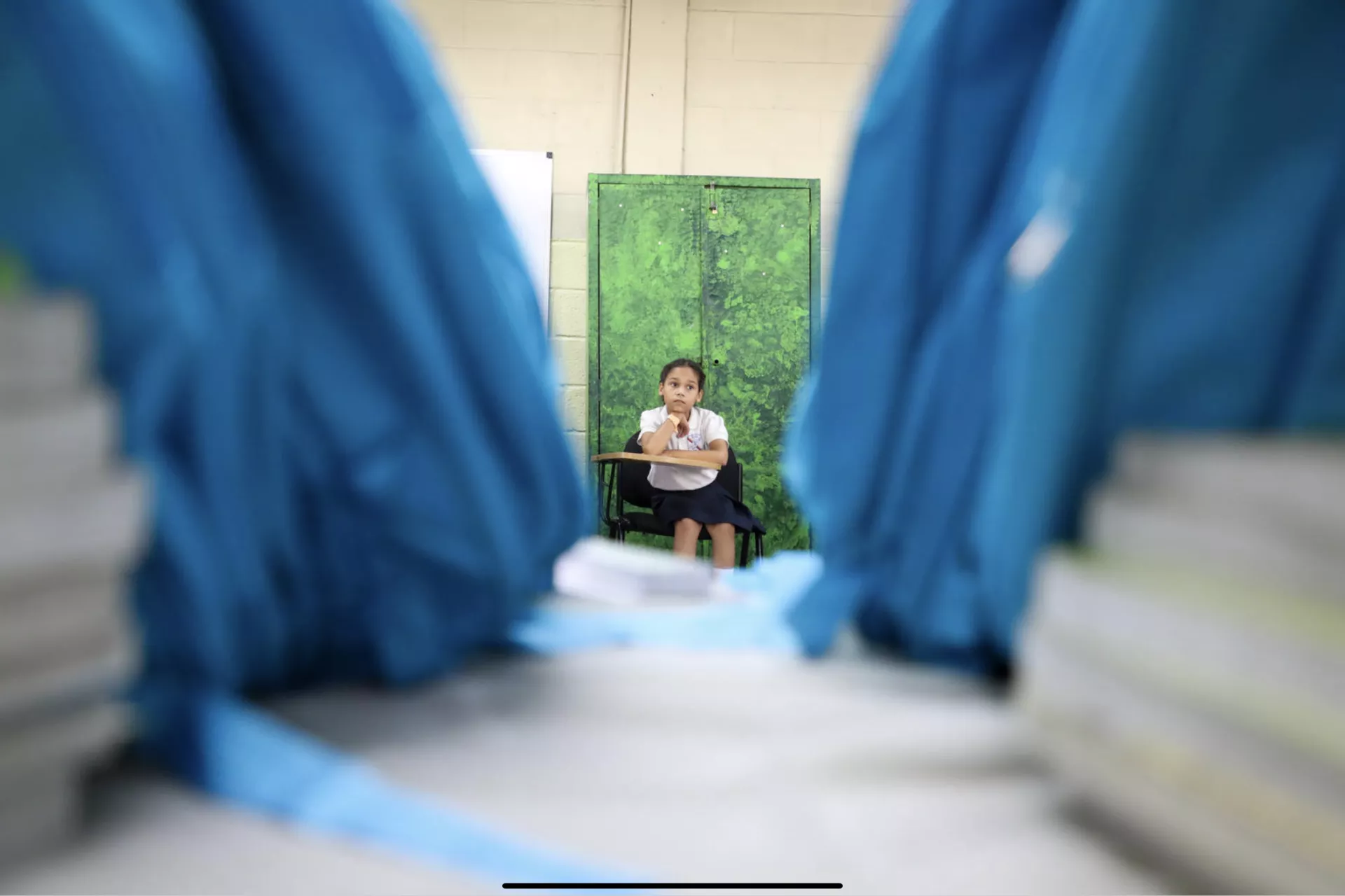 来自耶尔曼·乌巴尔多·里拉学校的一名女孩正在等待轮到她的教材材料回学校，包括学校用品和背包，米兰达省巴鲁塔，2019年9月。