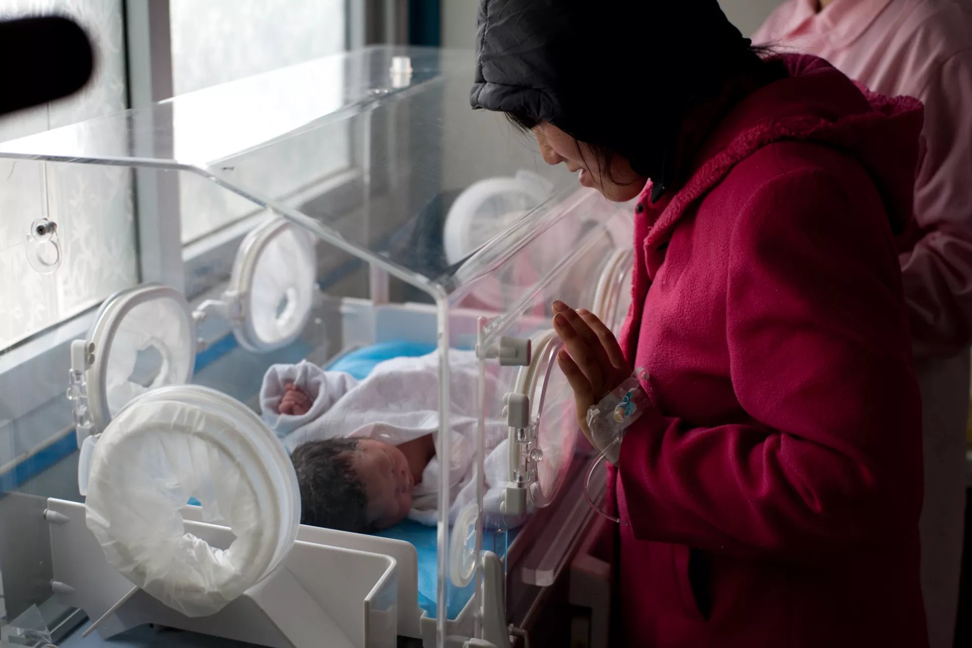 Zhang Chengmei, 26, watches her premature baby resting in an incubator that UNICEF provided to Qingchuan Maternal and Child Care Centre. 