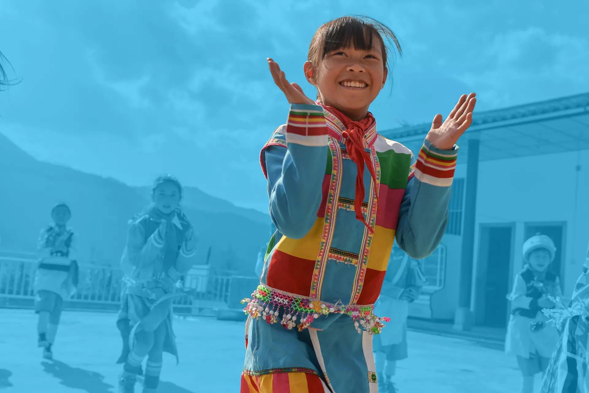 在云南省腾冲烧灰坝小学，一个女生和同学们一起跳舞。