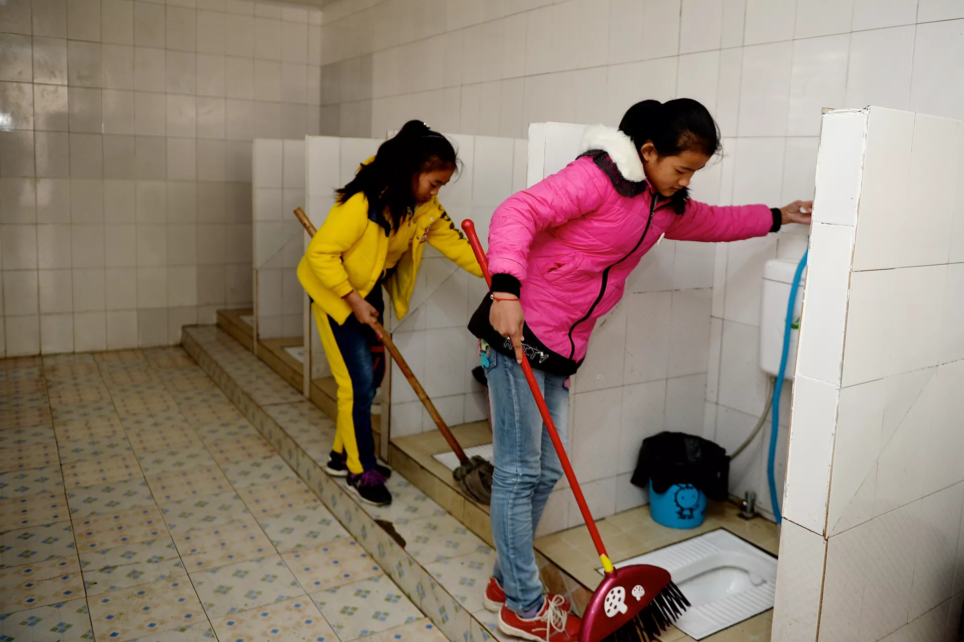 Two girls are tidying the toilet.