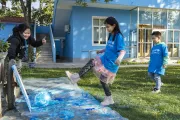2022年11月5日，在联合国儿童基金会驻华办事处，一名女孩将沾有蓝色颜料的足球踢向画布，绘制创意图画。