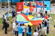Special Olympics athletes and other participants play the rainbow umbrella game together.