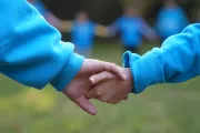 2022年11月19日，在位于北京的联合国大楼院内举行的庆祝世界儿童日活动中，一名成人与儿童手牵着手做游戏。