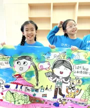 2023年11月18日，河北省保定市一儿童友好社区内，孩子们一起庆祝即将到来的世界儿童日，两名小女孩开心地举起她们手绘的儿童友好主题画作。