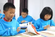 2023年11月11日，云南省瑞丽市举办世界儿童日庆祝活动，孩子们正在翻阅书本。
