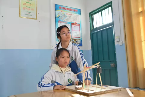 广西来宾市兴宾区迁江中学学生黄丽晨（左）、黄秋慧在调试自制投石机的准度（2023年12月28日摄）