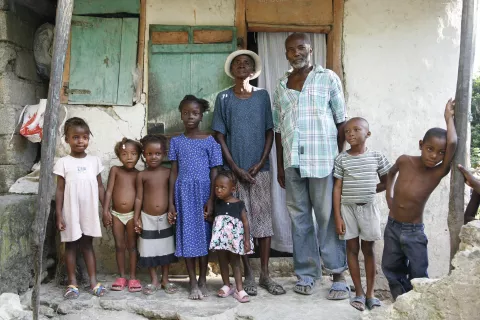 Mr and Mrs. Kebo Bouquet stand with some of their grandchildren outside their home, near the south-eastern town of Mirebalais in Central Plateau Department.