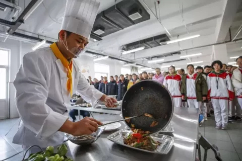Wu Kejian explained to 50 students attending a catering class how to make a nutritious meal with less oil and salt.