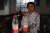 Gao Xiaoxiu, 12, shows two bottles of her water ration in her classroom.