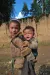 布拖县一名学龄女童背着年幼的弟弟。