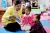 在湖北省宜昌市灵宝村的儿童早期发展中心，志愿者杨蓉给她的女儿（中）和另一名孩子读故事。