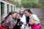 三名身着藏族传统服装的女学生簇拥着立陶宛国家委员会主席约维塔•马雅斯卡特，看着相机屏幕上自己的样子，脸上洋溢着灿烂的笑容。